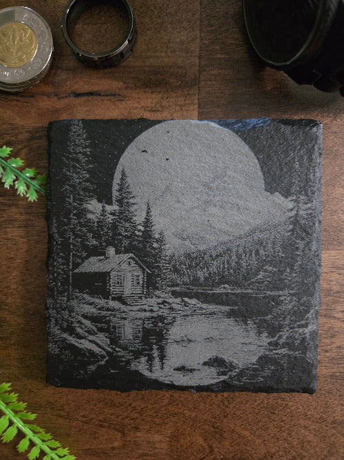 Slater coaster with engraved design on a wooden surface